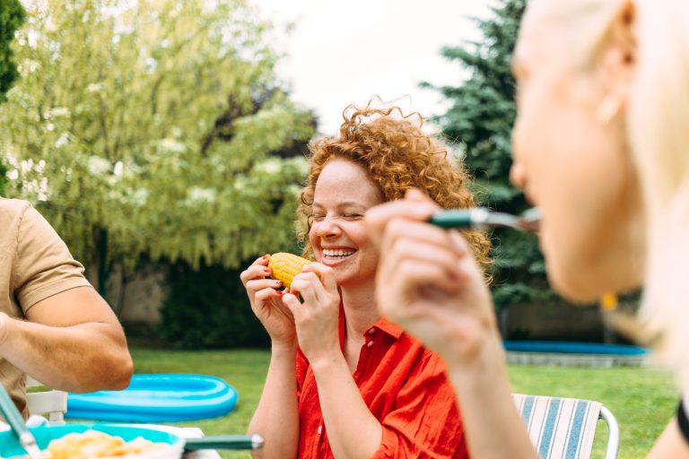 Friends laugh while eating and drinking