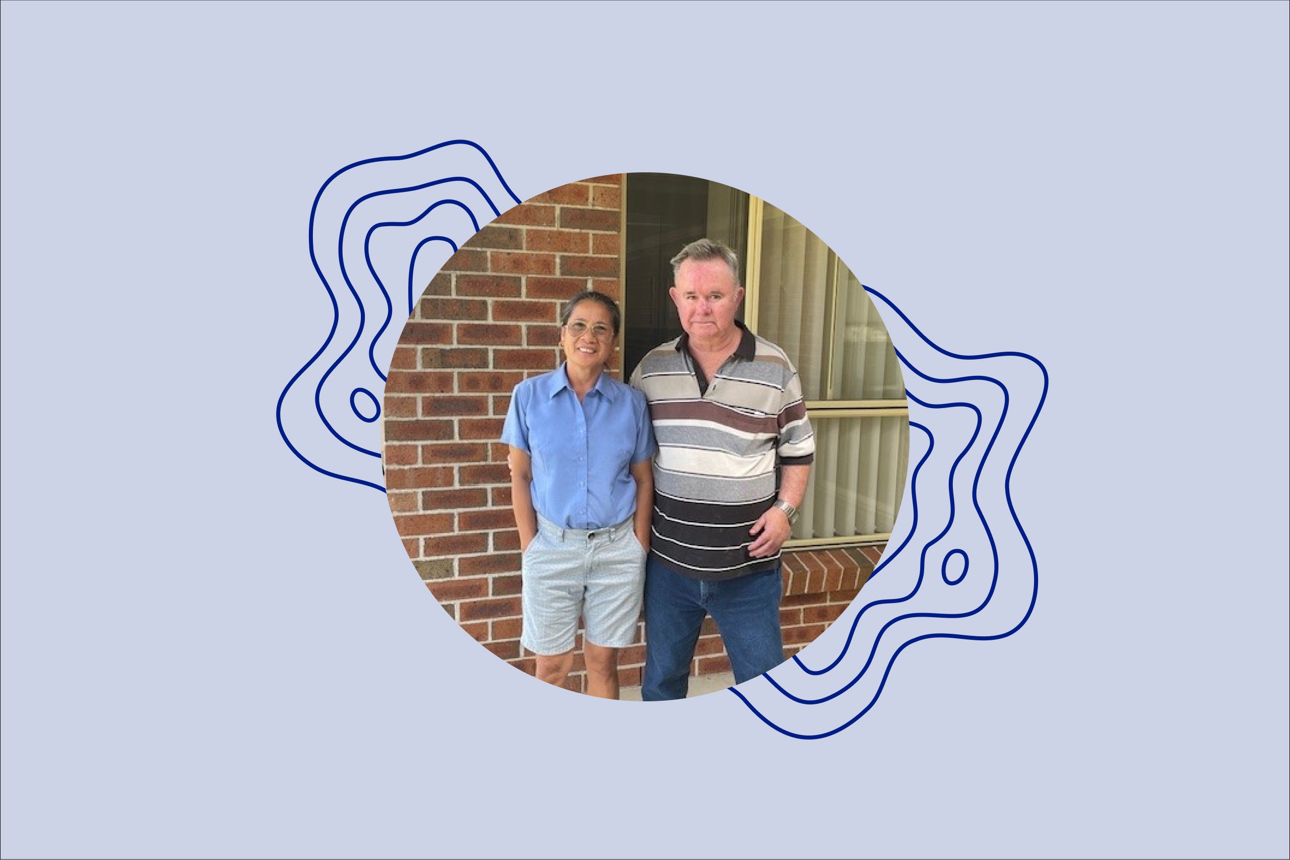 Image of Jeff standing next to one of his Support Workers in front of a brown brick wall with a window