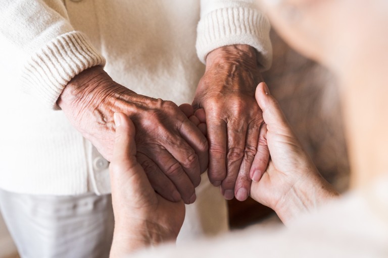elderly holding hands support at home