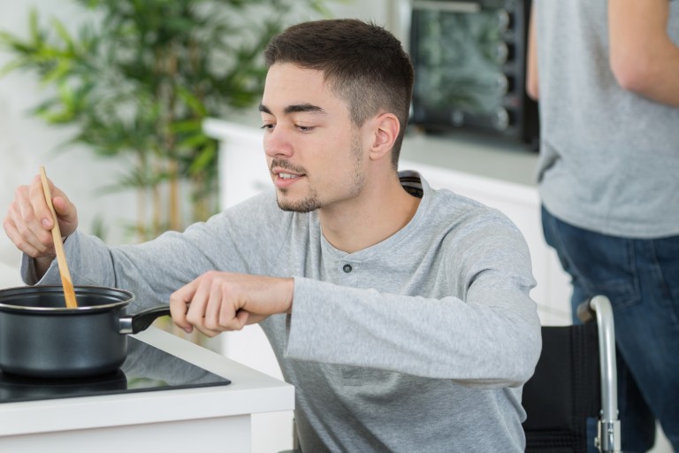 man stirring pot on stove