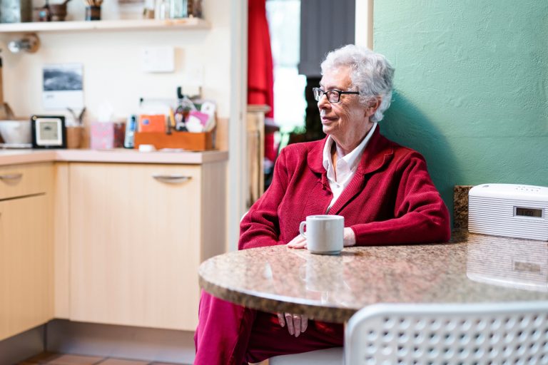 woman sitting at a table with a cup of tea